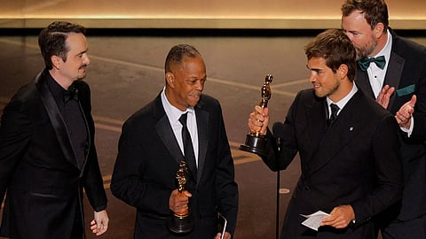 The team of The Singers and Two people Exchanging Saliva sharing Oscar awards